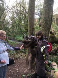 Nicki and her guide dog James exploring a tree carving during the Lisvane Ramble