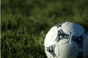 White leather football on a grassy football pitch