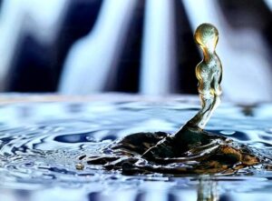 Zoomed in photograph of a water droplet. Picture shows a slow-motion capture of a droplet splashing into liquid.