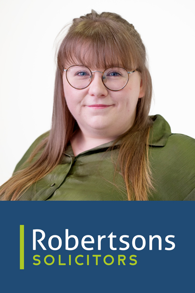 A profile image of Amy Palin looking to camera and smiling. She's wearing an olive green blouse and has glasses.