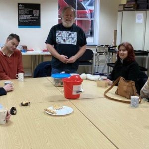 The Bird Chat group sat around the table with Lee standing to tell discuss different birds with them.