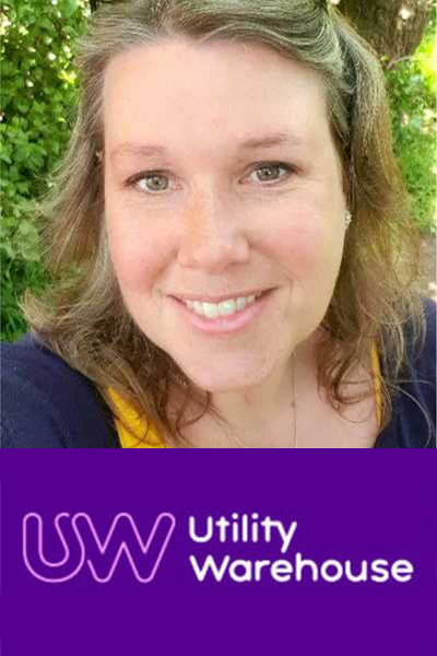 Photo of Hazel smiling to camera with sunglasses on her head with a green, leafy background