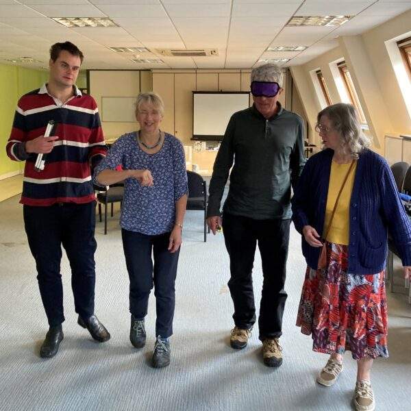 Picture of someone being guided whilst blindfolded