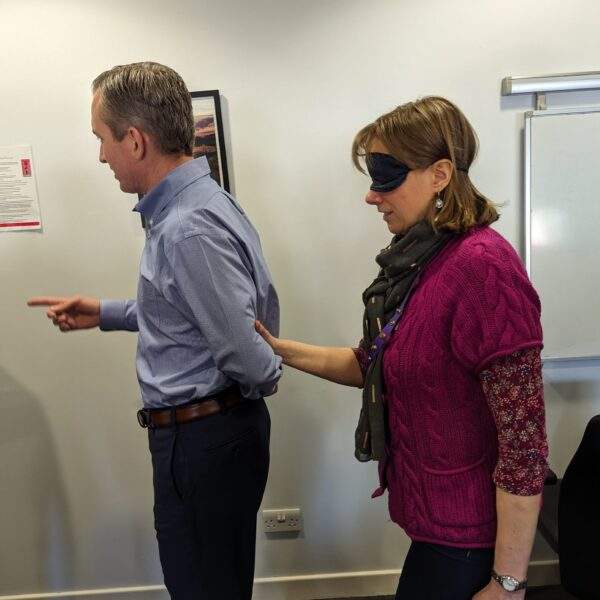 Picture of someone being guided whilst blindfolded